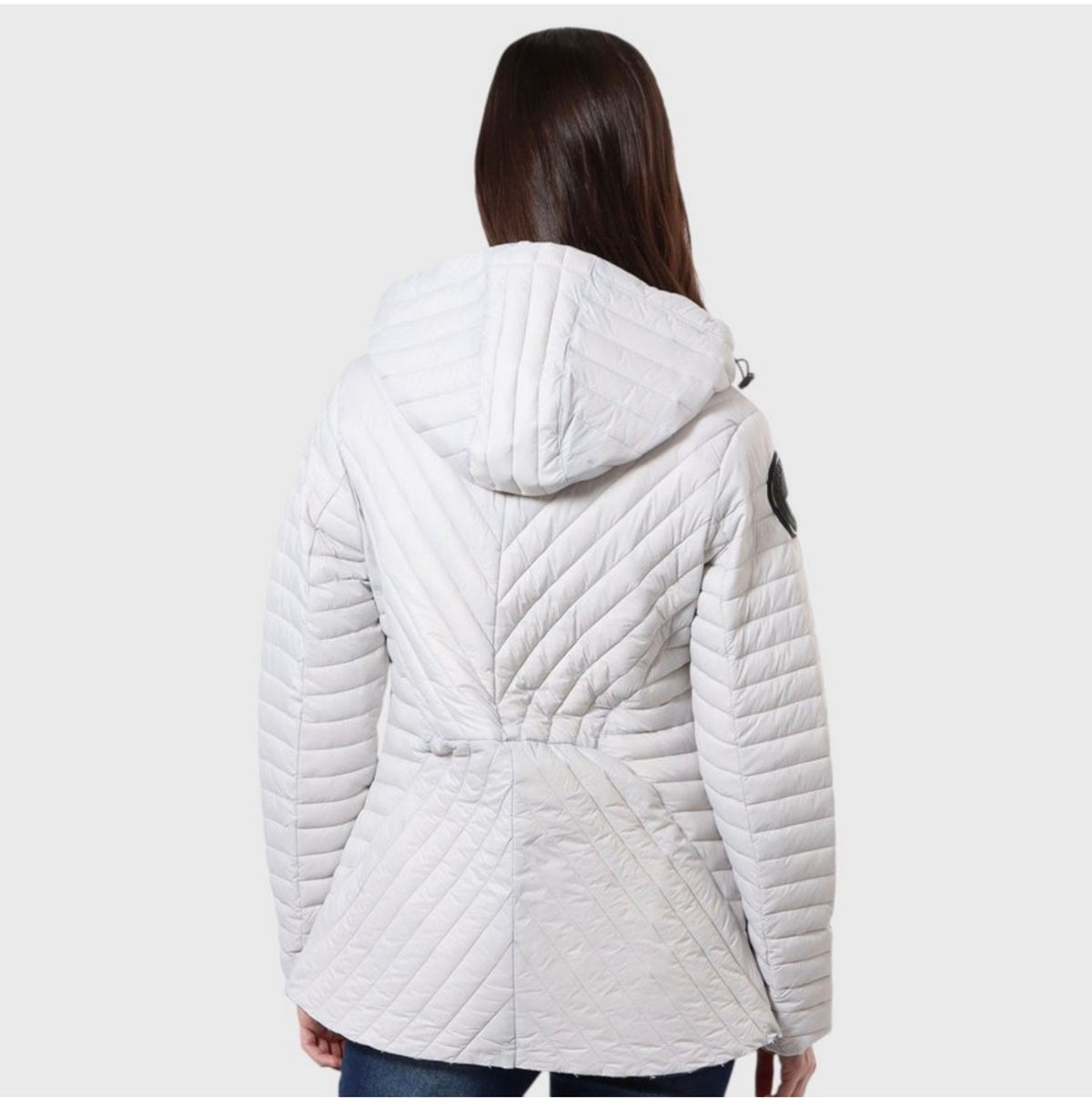 A woman viewed from the back wearing a white quilted hooded jacket with a wrap-style waist, against a light gray studio background. ##White