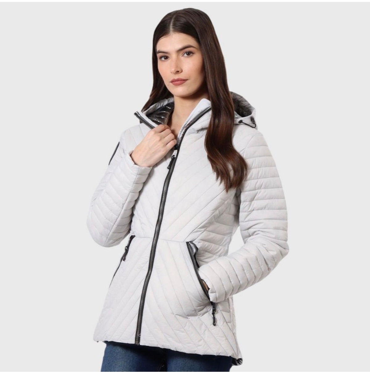 A woman modeling a white quilted puffer jacket with black zipper details and a black hood, set against a plain light gray background. ##White